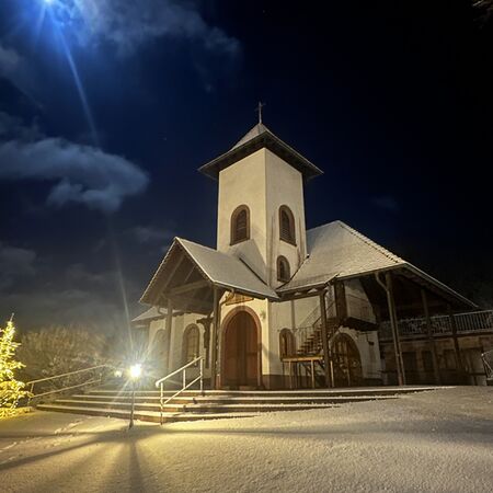 Verschneite Friedenskapelle bei Nacht